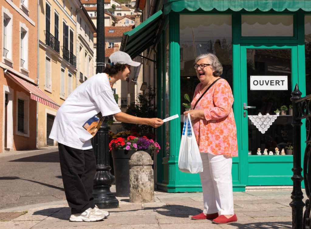 un jeun vend des tickets de tombola dans la rue